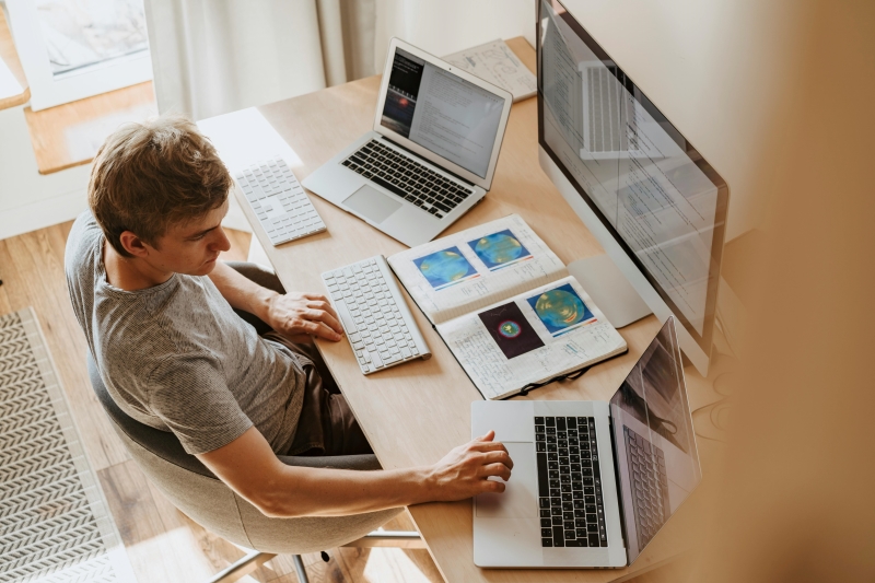 Laptop, Reisepass und Notizbuch auf einem Tisch in einem modernen Apartment